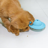 Puppy nosing the Treat Saucer on a tiled floor